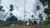 Seorang warga beraktivitas di dekat  infrastruktur jaringan 4G USO yang dikelola XL Axiata di Desa Mekar Jaya, Bunguran Barat, Natuna. (Ist.)
