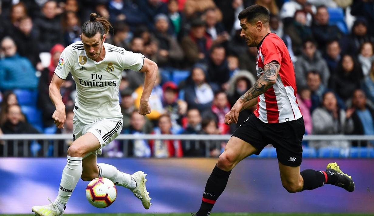 Aksi Gareth Bale melakukan manuver ke janung pertahanan Bilbao pada laga lanjutan La Liga di pekan ke-33 yang berlangsung di Stadion Santiago Bernabeu, Madrid, Minggu (21/4). Real Madrid menang 3-0 atas Bilbao. (AFP/Gabriel Bouys)