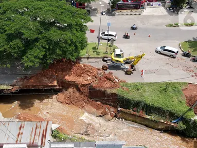 Pemandangan jalan ambles di ruas Jalan Boulevard, Grand Depok City (GDC), Kota Depok, Jawa Barat, Selasa (13/4/2021). Jalan ambles berada di atas gorong-gorong saluran kali. (Liputan6.com/Herman Zakharia)