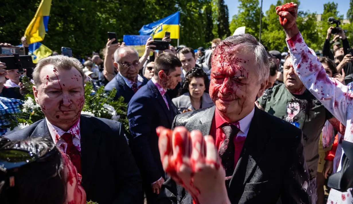 <p>Reaksi Duta Besar Rusia untuk Polandia, Sergey Andreev setelah ditutupi cat merah di Warsawa, Senin (9/5/2022). Para pengunjuk rasa yang memprotes perang di Ukraina melemparkan cat merah pada duta besar Rusia tersebut ketika Sergei Andreev tiba di pemakaman untuk meletakkan karangan bunga memperingati Victory Day atau Hari Kemenangan. (Wojtek RADWANSKI / AFP)</p>
