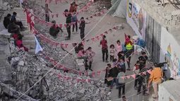 Meski hidup dalam keterbatasan, warga Palestina di Gaza tetap berupaya menghidupkan suasana Ramadan dengan beragam kreativitas. Tampa dalam foto, warga Palestina menggantungkan hiasan Ramadan di samping reruntuhan rumah yang hancur di Khan Younis, Jalur Gaza selatan, Minggu 15 Februari 2026. (AP Photo/Abdel Kareem Hana)