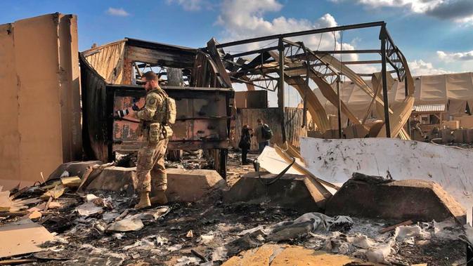 Tentara dan jurnalis AS memeriksa puing-puing di pangkalan udara Ain al-Asad, Anbar, Irak, Senin (13/1/2020). Iran menghujani pangkalan militer AS tersebut dengan rudal sebagai balasan atas kematian Jenderal Qasem Soleimani. (AP Photo/Qassim Abdul-Zahra)
