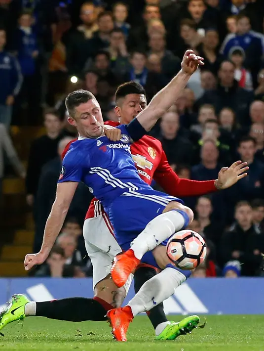 Pemain Chelsea, Gary Cahill (kiri) dan pemain Manchester United (MU), Marcos Rojo berebut bola dalam perempat final Piala FA di Stadion Stamford Bridge, Senin (13/3). Chelsea lolos ke semifinal Piala FA setelah menang 1-0 atas MU (AP Photo/Frank Augstein)