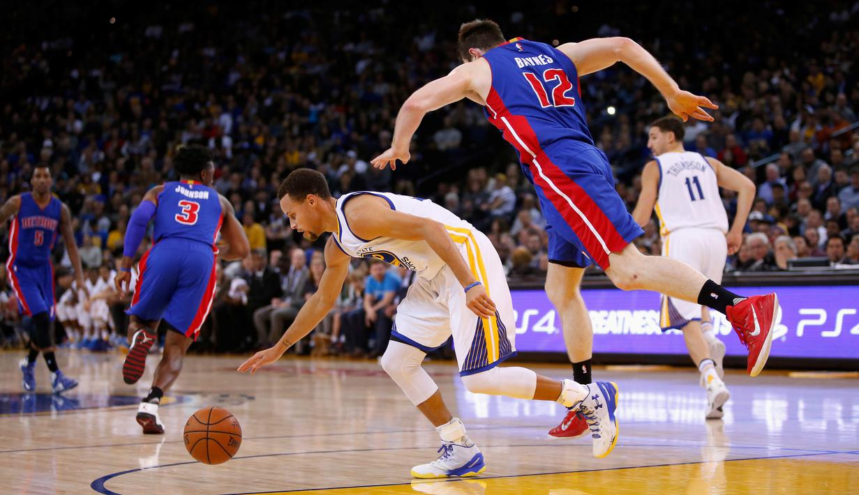 Pebasket Golden State Warriors Stephen Curry (kiri) berebut bola dengan pebasket Detroit Pistons Aron Baynes di ORACLE Arena, California, Senin (9/11/2015). Warriors menang 109-95. (Getty Images/AFP/Ezra Shaw)