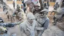 Orang-orang yang mengenakan pakaian militer tiruan ikut serta dalam perang makanan "Els Enfarinats" di Kota Ibi, Spanyol, 28 Desember 2022. (JAIME REINA/AFP)
