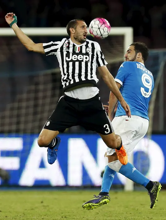 Penyerang Napoli, Gonzalo Higuain (kanan) berebut bola udara dengan bek Juventus, Giorgio Chiellini pada lanjutan liga Italia di Stadion San Paolo, Minggu (27/9/2015). Napoli menang atas Juventus dengan skor 2-1. (REUTERS/Ciro De Luca)
