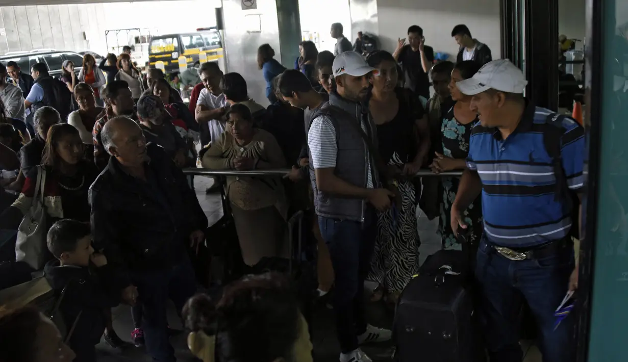 Sejumlah calon penumpang terlihat di luar bandara internasional La Aurora yang tutup akibat abu vulkanik gunung berapi Fuego di Guatemala City, Minggu (3/6). Tujuh orang tewas dan 300 lainnya terluka akibat letusan gunung berapi Fuego. (AFP/JOHAN ORDONEZ)