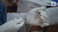 Petugas kesehatan menyiapkan vaksin COVID-19 untuk disuntikan kepada warga Kelurahan Gedong di Jakarta, Rabu (23/6/2021). Vaksin bisa mengurangi tingkat keparahan infeksi dan kematian akibat virus, termasuk yang disebabkan varian Delta. (merdeka.com/Imam Buhori)