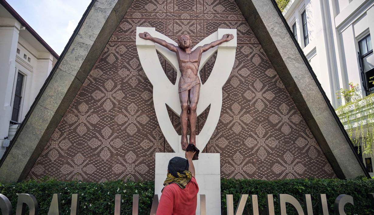 Di antaranya, dengan membersihkan kembali beberapa sudut bangunan dari debu. Tampak dalam foto, seorang pekerja membersihkan patung Yesus di Katedral Hati Kudus Yesus, yang dikenal secara lokal sebagai gereja "Hati Kudus Yesus", selama persiapan Misa Natal di Surabaya, Jawa Timur, pada Selasa 23 Desember 2025. (JUNI KRISWANTO/AFP)