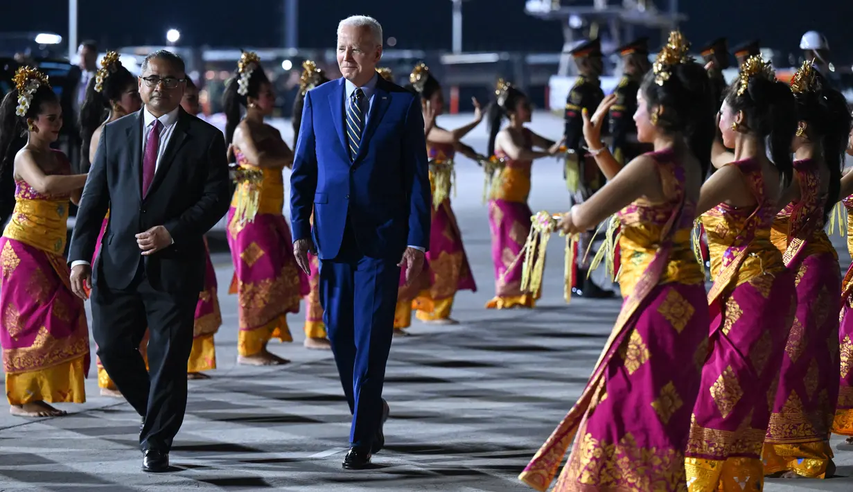 Presiden Amerika Serikat (AS) Joe Biden disambut oleh tarian khas Bali saat turun dari pesawat kepresidenan AS, Air Force One setibanya di Bandara I Gusti Ngurah Rai Bali, Minggu (13/11/2022). ruas Jalan Airport Ngurah Rai langsung disterilkan begitu pesawat Air Force One yang digunakan Joe Biden mendarat.  (SAUL LOEB / AFP)