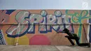 Seorang anak dari komunitas mural setempat saat berpatisipasi menggambar tembok yang berada di pinggir Jalan Landasan Pacu, Kemayoran, Jakarta, Rabu (11/7). (Merdeka.com/Iqbal S. Nugroho)