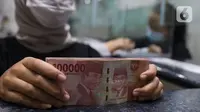 Teller menunjukkan uang rupiah di money changer, Jakarta, Rabu (9/9/2020). US$ 1 dibanderol Rp 14.780/US$ di pasar spot. Rupiah melemah 0,14% dibandingkan dengan penutupan perdagangan kemarin. (Liputan6.com/Angga Yuniar)