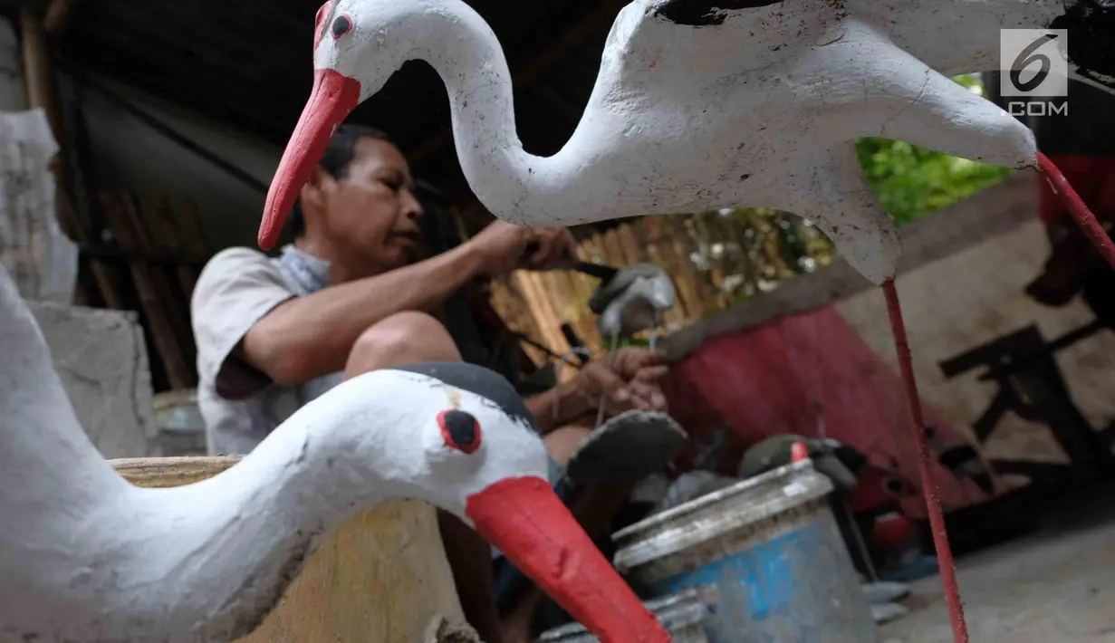 Pengrajin membuat patung di Jakarta, Jumat (16/3). Pemerintah berencana menurunkan tarif pajak penghasilan atas penjualan dibawah Rp4,8 miliar yang dikenakan tarif PP 46 sebesar 1% per bulan dari jumlah omzet, menjadi 0,5%. (Liputan6.com/Angga Yuniar)