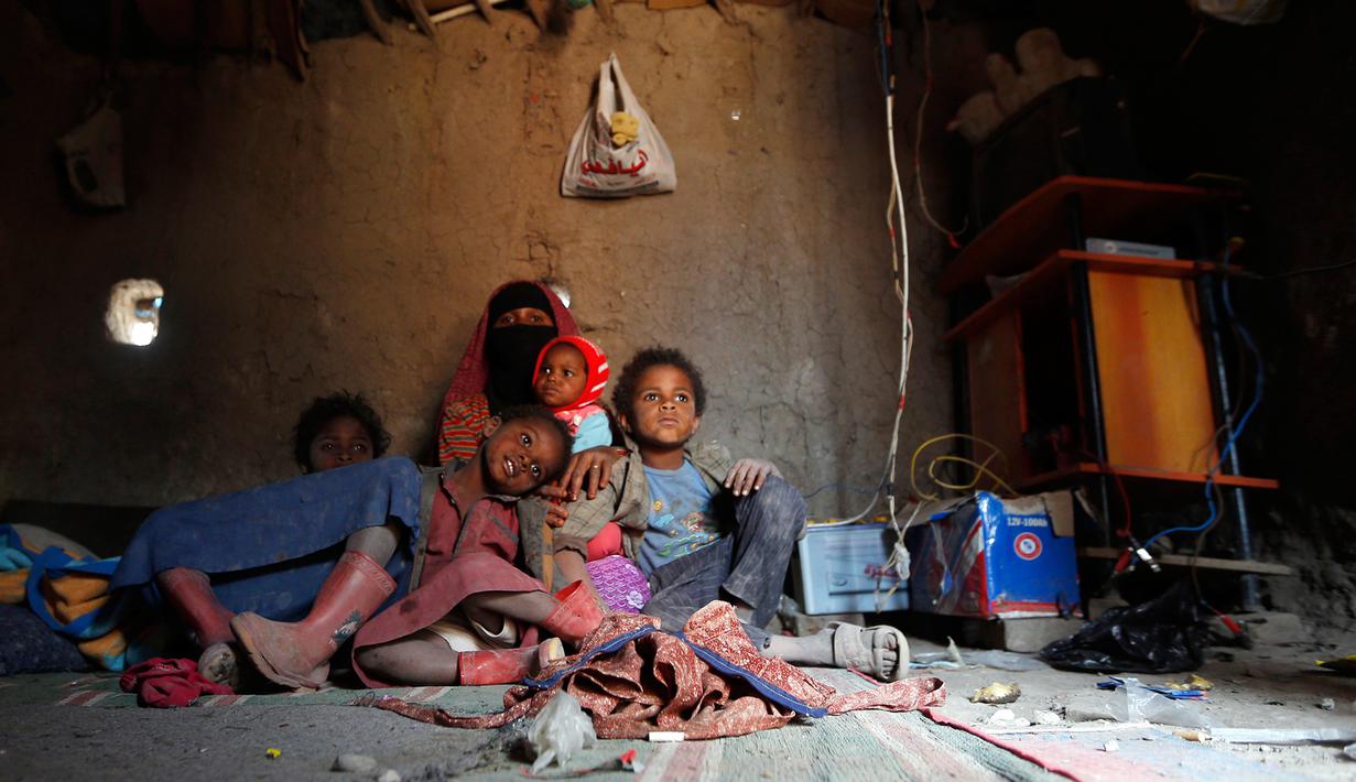 Seorang wanita Yaman bersama anak-anaknya berada di tenda tempat tinggal mereka di kamp pengungsian di Sanaa, Yaman, (15/4). Jutaan warga melarikan diri hingga ke wilayah dataran tinggi seperti Taez. (AFP Photo / Mohammed Huwais)