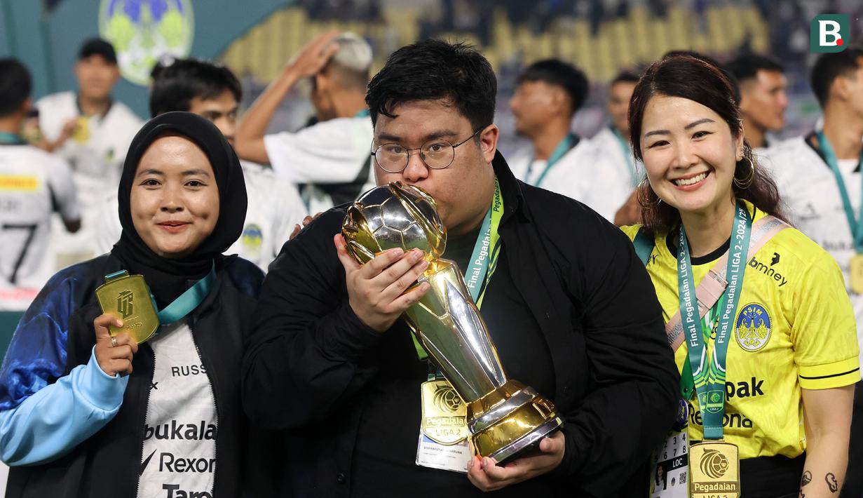 Manajer PSIM, Razzi Taruna (tengah) mencium trofi juara Pegadaian Liga 2 2024/2025 setelah mengalahkan Bhayangkara FC dalam laga final yang berlangsung di Stadion Manahan, Solo, Jawa Tengah, Rabu (26/02/2025). (Bola.com/Abdul Aziz)