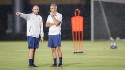 Pelatih Timnas Prancis U-17, Jean Luc Vannuchi (kanan) berdiskusi dengan salah satu tim pelatihnya melakukan latihan di bawah hujan jelang laga final Piala Dunia U-17 2023 melawan Timnas Jerman U-17 di Stadion Sriwedari, Solo, Jawa Tengah, Kamis (30/11/2023). (Bola.com/Bagaskara Lazuardi)