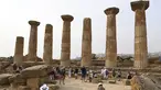 Turis saat mengunjungi Lembah Kuil selama gelombang panas di dekat Agrigento, Sisilia, Italia (11/8/2021). Gelombang panas yang berkelanjutan akan berlangsung hingga akhir pekan dengan suhu diperkirakan mencapai lebih dari 40 derajat Celcius di banyak bagian dari Italia. (AP Photo/Salvatore Cavalli)