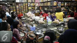 Sejumlah calon pembeli mengantre membeli kue kering di Pasar Jatinegara, Jakarta, Senin (27/6). Alasan warga membeli panganan khas lebaran di toko kue karena lebih praktis dan terjangkau harganya. (Liputan6.com/Faizal Fanani)
