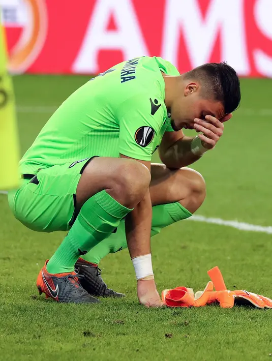 Kiper Lazio, Thomas Fotaq Strakosha bereaksi setelah kalah telak dari Red Bull Salzburg pada leg kedua perempat final Liga Europa di Red Bull Arena, Jumat (13/4). Lazio gagal melangkah ke semifinal usai disingkirkan Salzburg 1-4. (KRUGFOTO/APA/AFP)