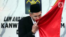 Pemain sepak bola Sandy Walsh mencium bendera Merah Putih usai menjalani Sumpah Janji Setia Pewarganegaraan di Kantor Wilayah Kementerian Hukum dan HAM DKI Jakarta, Kamis (17/11/2022). Sandy Walsh resmi menjadi Warga Negara Indonesia (WNI) setelah prosesi pengambilan sumpah yang digelar secara tertutup. (Liputan6.com/Herman Zakharia)