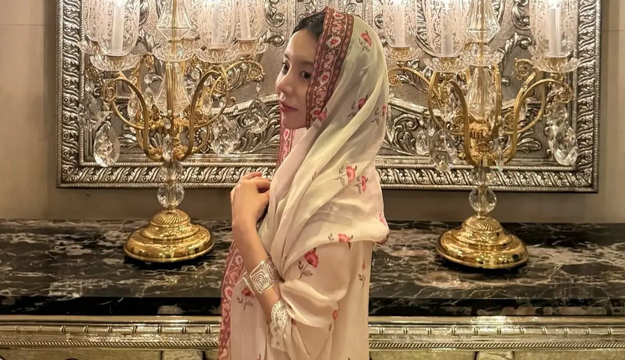 Pada 15 Desember, Jiwoo mengunggah serangkaian foto di Instagram yang memperlihatkan dirinya mengenakan salwar kameez lengkap dengan aksesori tradisional seperti gelang tipis dan sepatu jutti unik. Ia terlihat berpose dengan anggun, mengenakan dupatta di kepalanya, sebuah gestur yang dihormati dalam budaya India. (Liputan6.com/IG/@mejiwoo103)