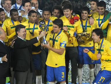 Kapten Timnas Brasil U-20, Bruno Uvini (tengah), menerima trofi Piala Dunia U-20 2011 setelah mengalahkan Portugal U-20 yang berlangsung di Bogota, Kolombia, Sabtu (20/8/2011). Brasil menang 3-2 atas Portugal lewat babak perpanjangan waktu. (AFP/Eitan Abramovich)