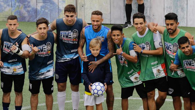 Bintang sepak bola Brasil, Neymar (tengah) dan putranya Davi Lucca foto bersama pemain Argentina (kiri) dan Meksiko saat turnamen untuk badan amal Neymar Junior Project Institute di Praia Grande, Sao Paulo, Brasil, Sabtu (21/7). (AP Photo/Nelson Antoine)