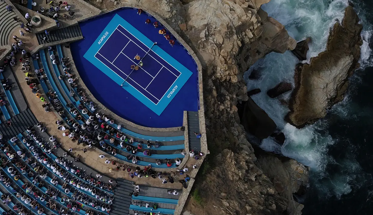 Pemandangan dari udara, sebuah musikus Mariachi tampil saat pertandingan tenis eksibisi antara petenis Austria Dominic Thiem melawan petenis Jerman Alexander Zverev di forum "Sinfonia del Mar" di Acapulco, Meksiko (26/2). (AFP Photo/Pedro Pardo)