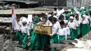 Murid MI Yayasan Nurul Bahri melakukan pawai usai menulis surat untuk Presiden Jokowi, di perkampungan nelayan Muara Angke, Jakarta, Senin (27/2). Kegiatan itu juga sebagai kepedulian pada dunia literasi untuk anak Indonesia. (Liputan6.com/Faizal Fanani)