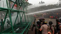 Polisi menembakkan air menggunakan water cannon ke arah mahasiswa saat demonstrasi menolak pengesahan RUU KUHP dan revisi UU KPK di depan Gedung DPR, Jakarta, Selasa (24/9/2019). Polisi menghalau mahasiswa yang berusaha masuk ke area Gedung DPR. (Liputan6.com/JohanTallo)