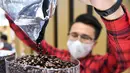 Seorang staf menuang biji kopi ke dalam mesin pembuat kopi di stan jaringan restoran cepat saji asal Kanada, Tim Hortons, di area ekshibisi Produk Makanan dan Pertanian Pameran Impor Internasional China (China International Import Expo/CIIE) ketiga di Shanghai, China timur (5/11/2020). (Xinhua/Chen