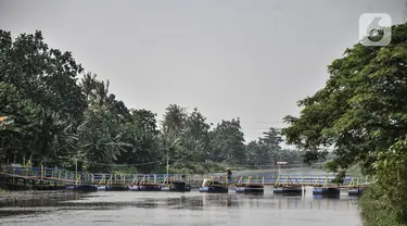 Suasana jembatan apung Kali CBL di Desa Sukamekar, Kecamatan Sukawangi, Kabupaten Bekasi, Jawa Barat, Kamis (17/2/2022). Jembatan apung yang dibuat secara mandiri ini merupakan inisiasi warga sebagai akses penghubung masyarakat akibat minimnya jembatan penyeberangan. (merdeka.com/Iqbal S. Nugroho)