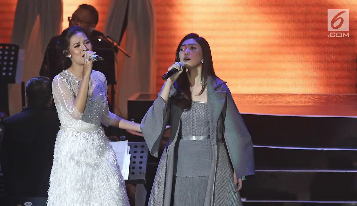 Penyanyi Raisa (kiri) dan Isyana Sarasvati berkolaborasi saat tampil pada konser Colours of Love di Jakarta, Rabu (20/12). Film Ayat-ayat Cinta 2 yang mulai tayang Kamis 21 Desember 2017. (Liputan6.com./Herman Zakharia)