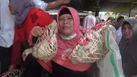 Salah seorang jemaah majelis tarbiyah, Wanaraja, Garut, Jawa Barat nampak tengah menerima pemberian 2 ekor ayam dalam perayaan 1 Muharram 1441 Hijriah di Garut (Liputan6.com/Jayadi Supriadin)