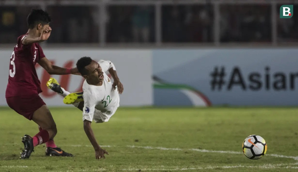 Gelandang Timnas Indonesia, Todd Rivaldo, dijatuhkan pemain Qatar pada laga AFC U-19 Championship di SUGBK, Jakarta, Minggu (21/10). Indonesia kalah 5-6 dari Qatar. (Bola.com/Vitalis Yogi Trisna)