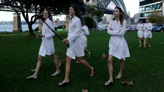 Sejumlah model berjalan dengan tongkat selfienyadi samping jembatan Sydney Harbour Bridge dalam perjalanan ke lokasi catwalk acara Manning Cartell di Australia Fashion Week, 17 Mei 2016. (REUTERS/Jason Reed)