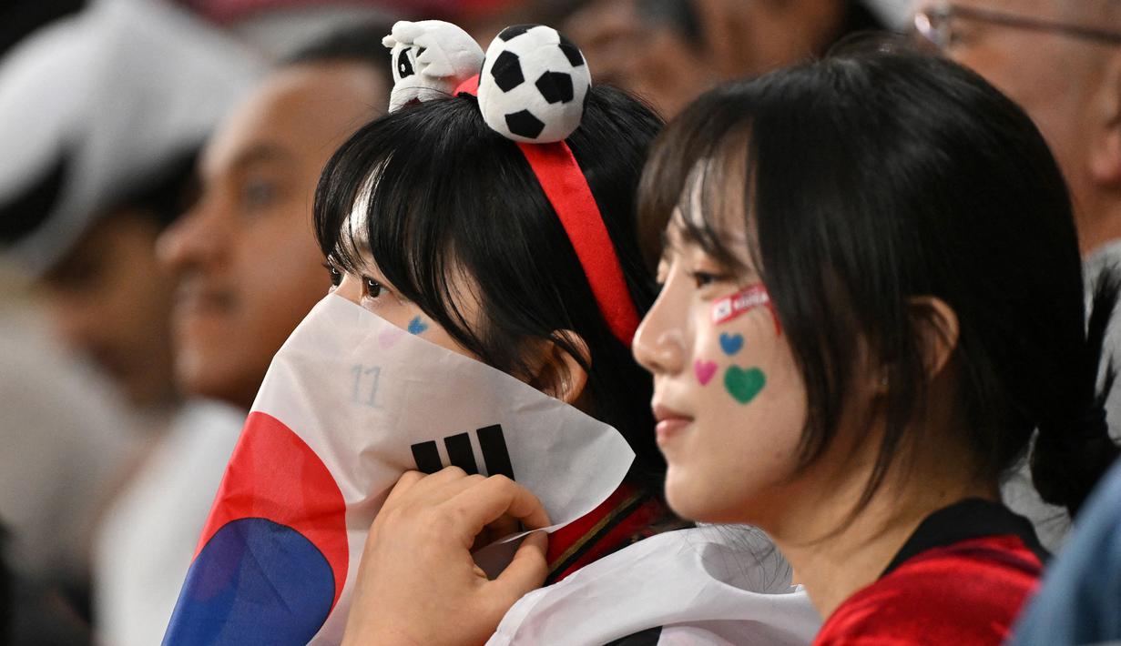 Ekspresi kecewa suporter Korea Selatan setelah timnya dikalahkan Yordania pada laga semifinal Piala Asia 2023 di Ahmad Bin Ali Stadium, Doha, Qatar, Selasa (06/02/2024). Korea Selatan kalah dengan skor 0-2. (AFP/Hector Retamal)