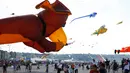 Orang-orang menerbangkan layang-layang selama Festival Layang-layang Internasional Dieppe ke-20 di Dieppe, Prancis, Minggu (9/9). Acara yang diadakan hingga 16 September ini mengumpulkan ribuan orang dari 34 negara. (AFP/CHARLY TRIBALLEAU)
