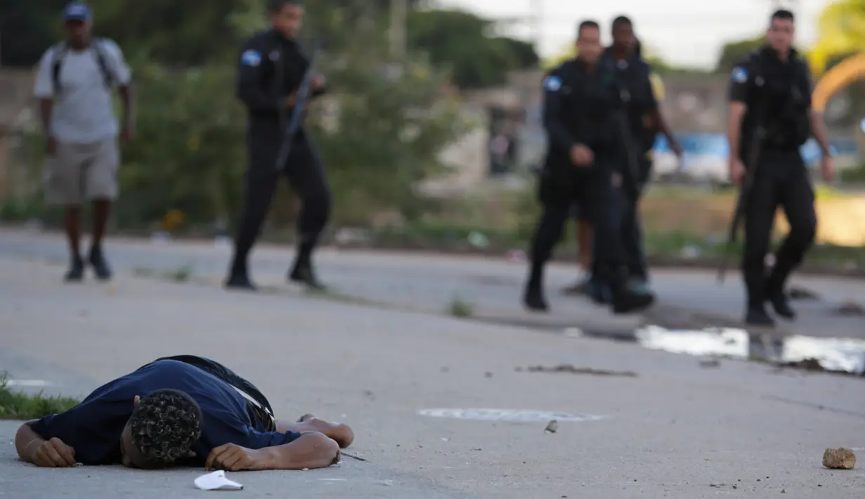 Jenazah yang diduga pengedar narkoba tergeletak di Pavuna, Rio de Janeiro, Brasil, Kamis (30/3). Dua pengedar tewas saat konfrontasi dengan pihak kepolisian. (AP Photo / Diego Herculano)