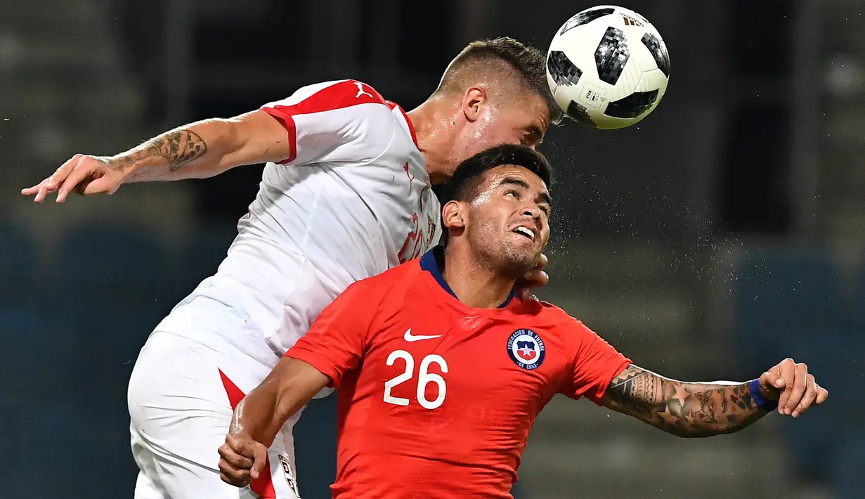 Duel udara pemain Serbia, Sergej Milinkovic Savic (kiri) dan peain Chili, Sebastian Vegas pada laga uji coba di Merkur Arena, Graz, Austria, (4/6/2018).  Serbia kalah dari Chili 0-1. (AFP/Joe Klamar)