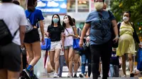 Dua wanita mengenakan masker sebagai tindakan pencegahan Covid-19 saat berjalan di Hong Kong (13/5/2020). Dua orang di Hong Kong dinyatakan positif Covid-19, mengakhiri perjalanan 24 hari tanpa kasus baru yang mulai melonggarkan peraturan jarak sosial. (AFP/Anthony Wallace)