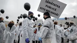 Para petugas medis yang mengenakan masker memegang balon hitam di Bucharest, Rumania, Selasa (17/11/2020). Aksi tersebut untuk mengenang pasien COVID-19 yang tewas dalam kebakaran di instalasi gawat darurat rumah sakit di Piatra Neamt, Rumania pada 14 November 2020 lalu. (AP Photo/Vadim Ghirda)