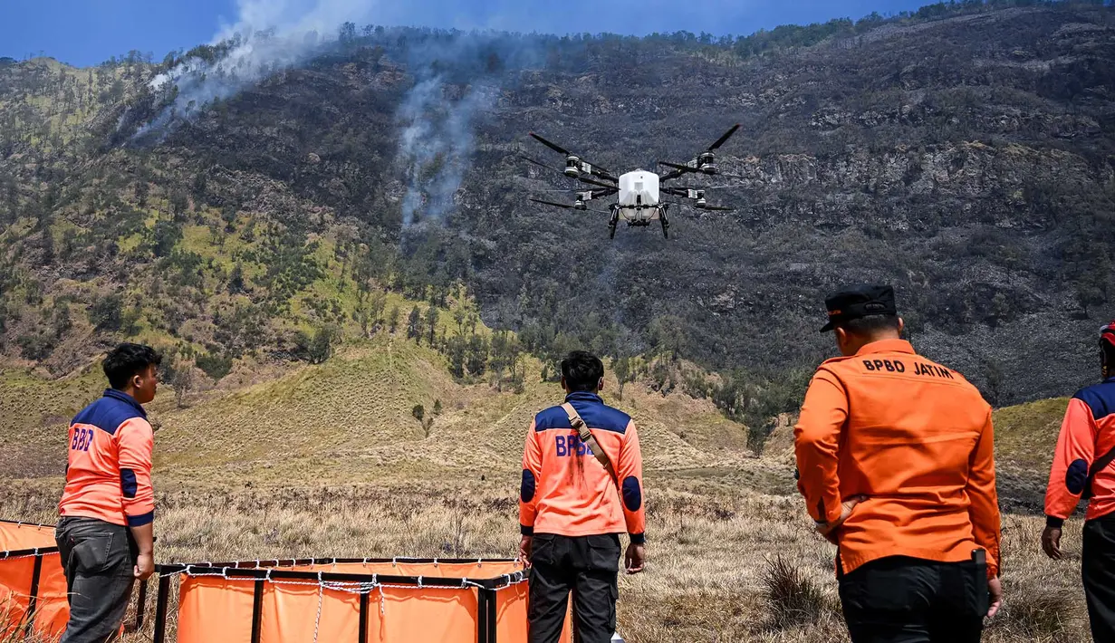 Petugas mengoperasikan drone water spray untuk memadamkan kebakaran hutan dan lahan (karhutla) di kawasan Taman Nasional Bromo Tengger Semeru (TNBTS), Kabupaten Probolinggo, Jawa Timur, Kamis (6/8/2026). (AFP/ Juni Kriswanto)