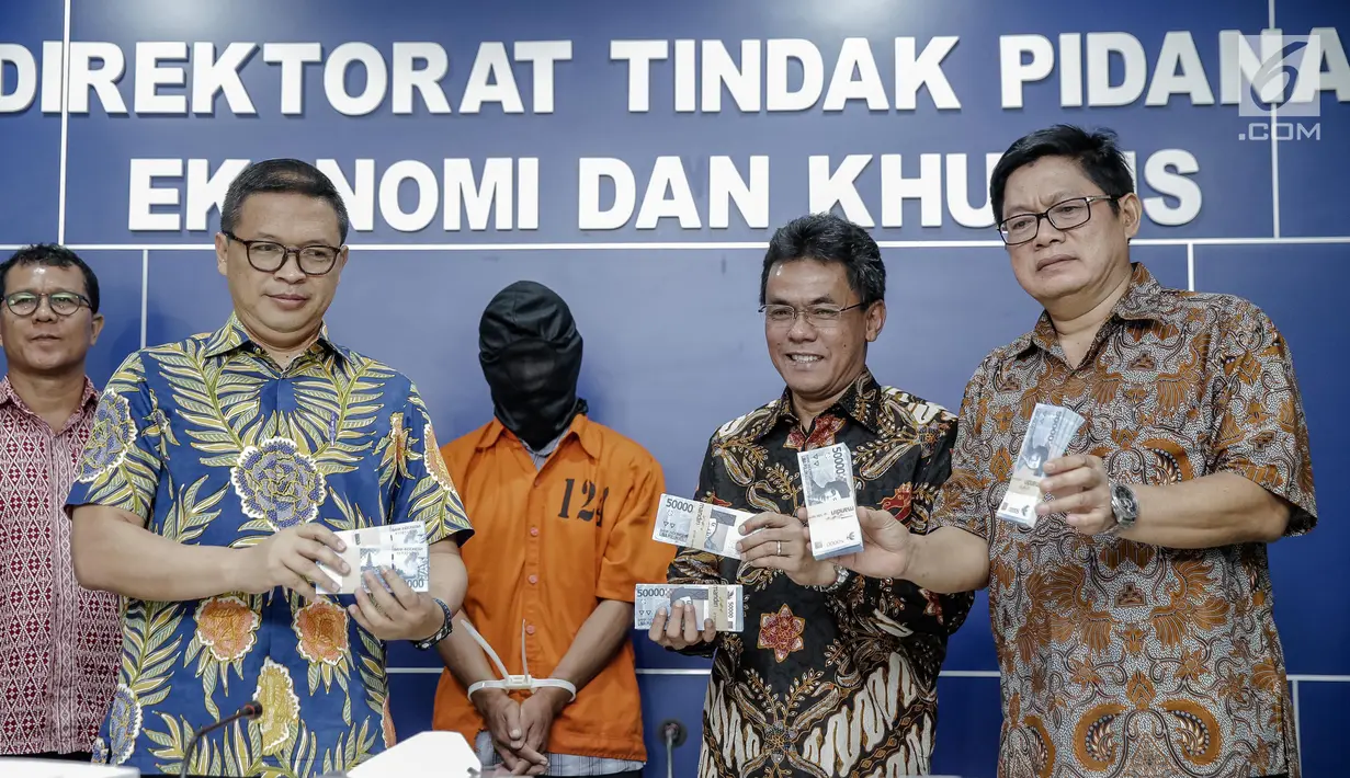 Dirtipideksus, Brigjen Agung Setya (kedua kanan) menunjukan uang palsu saat rilis di Bareskrim Polri, Jakarta, Jumat (16/6). Dalam penangkapan polisi mengamankan 1.000 lembar uang pecahan Rp 50.000 palsu. (Liputan6.com/Faizal Fanani)
