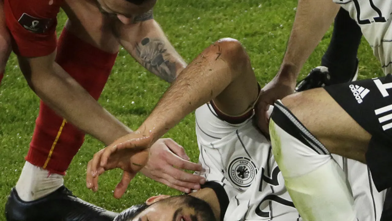 Pemain Jerman Ilkay Gundogan membantu rekannya, Emre Can