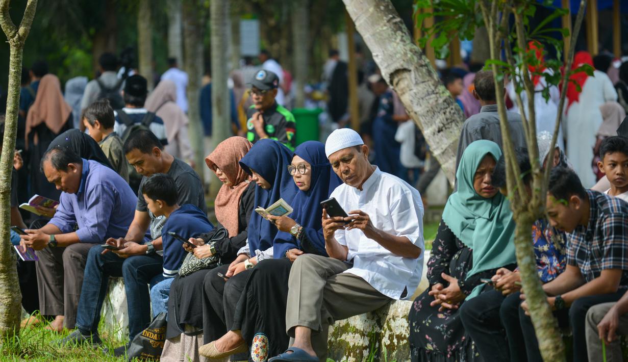 Orang-orang berdoa saat memperingati 18 tahun musibah gempa dan tsunami di kuburan massal Siron, Aceh, Senin (26/12/2022). Tsunami Aceh pada 2004 merenggut nyawa lebih dari 170.000 orang di Indonesia saja. (AFP/Chaideer Mahyuddin)