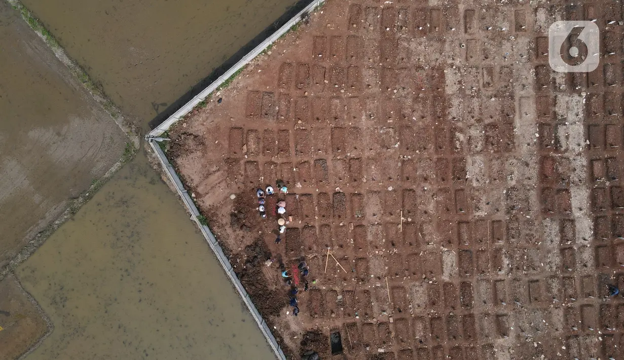 Pantauan udara menunjukkan pekerja dibantu alat berat menyiapkan lahan untuk lokasi pemakaman khusus Covid-19 di Rorotan, Jakarta Utara, Kamis (3/6/2021). Sejak mulai dibuka pada akhir Maret lalu, TPU ini diutamakan melayani pemakaman bagi jenazah Covid-19 yang ber-KTP DKI. (merdeka.com/Imam Buhori)
