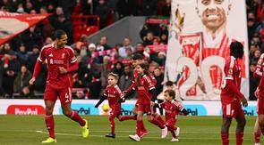 Anak-anak Diogo Jota ikut berjalan ke lapangan sebagai pendamping maskot pemain saat Liverpool versus Wolverhampton Wanderers pada laga pekan ke-18 Premier League di Stadion Anfield, Sabtu (27/12/2025) malam WIB. (AFP/Oli Scarff)