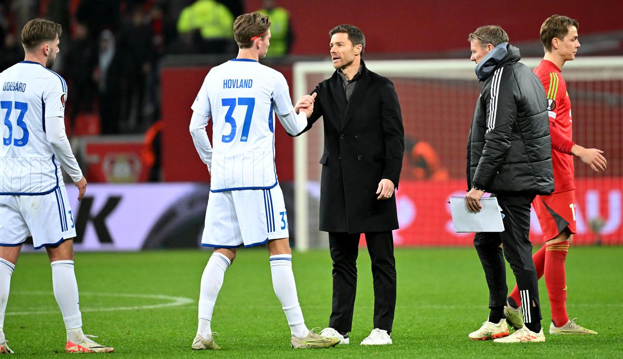 <p>Pelatih Bayer Leverkusen, Xabi Alonso, menyalami pemain Molde FK dalam laga matchday 6 Grup H Liga Europa 2023/2024 yang digelar di BayArena, Jumat (15/12/2023). Berkat tangan dinginnya Bayer masih kukuh di puncak klasemen dengan 36 poin dari 14 laga. Setali tiga uang di Liga Europa. Leverkusen sempurna di fase grup Liga Europa dengan enam kemenangan dari enam laga. (AFP/Ulrich Hufnagel)</p>
