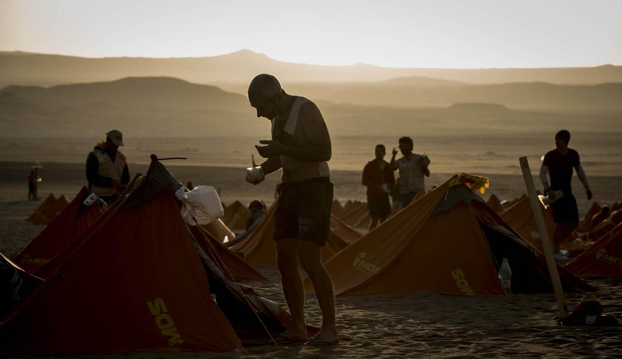 Para peserta bersiap kembali berjalan saat mengikuti lomba marathon sejauh 250 kilometer di Gurun Ica, Kamis (30/11/2017). Marathon yang terbagi dalam enam tahapan ini diprediksi akan berakhir pada 4 Desember. (AFP/Jean-Philippe Ksiazek)